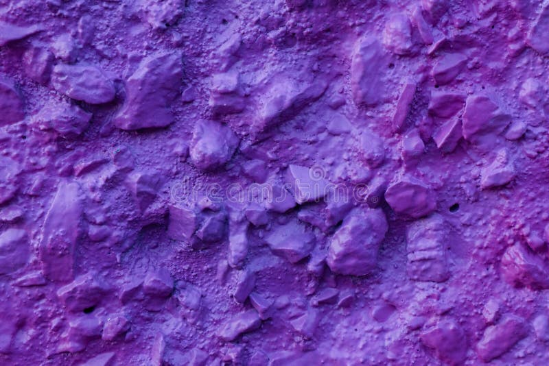 Abstract texture of concrete wall covered uneven decorative stucco and painted bluish-purple paint. Decorative relief plaster. Violet painted relief wall with stock image