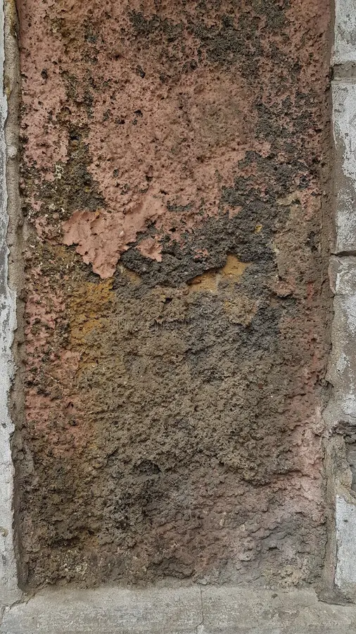 Grunge backdrop of old rough stone wall surface of ruined building. Dilapidated dirty wall texture closeup with damaged rough brown stucco surface. Grunge royalty free stock images