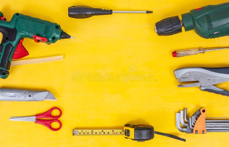 DIY Do it yourself tools on yellow background. DIY tools with copy space for text on yellow wooden background. Different tools for stock photos