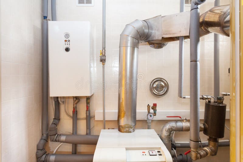 A domestic household boiler room with a new modern solid fuel boiler , heating electric warm water system and pipes. royalty free stock image