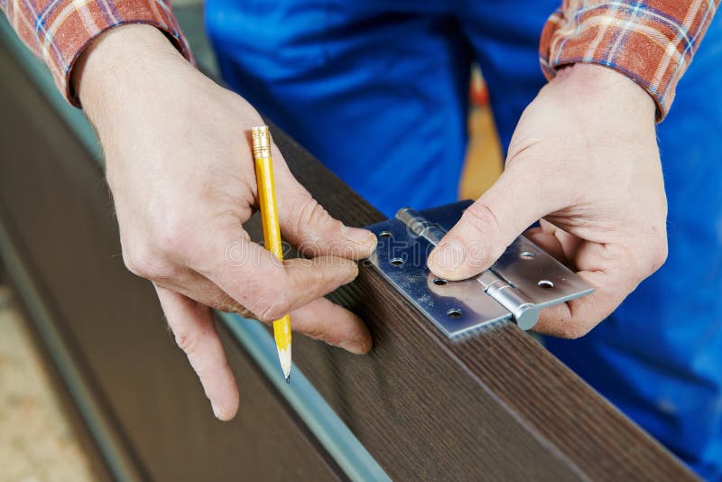 Door hinge installation. Close-up carpenter process of wood door hinge installation royalty free stock images