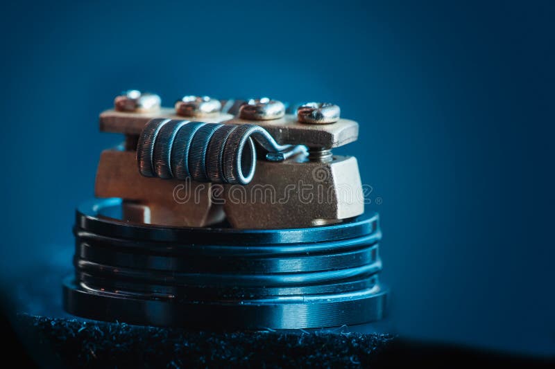 Electronic cigarette for vape. Winding close-up for electronic cigarettes from nichrome, fecral. vape. Staggerton Fused Clapton Coil on Dripper for vaping royalty free stock image