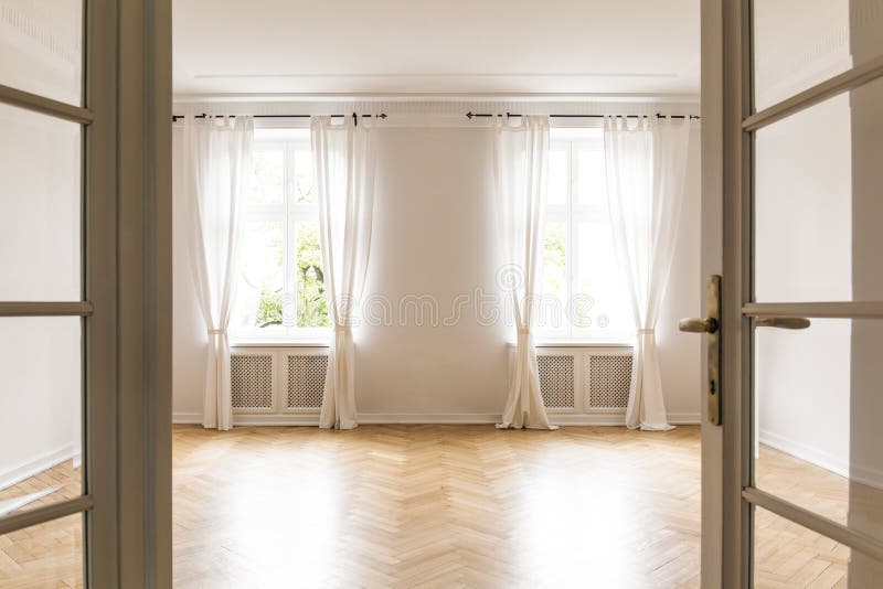 Empty bright living room interior with drapes at windows and woo stock images