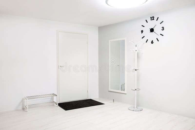 Empty hallway entrance with few furnishing elements, white and gray walls and flooring. stock image