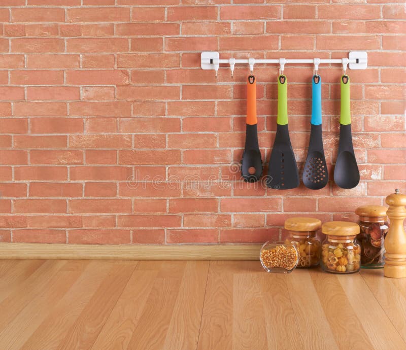 Empty space on the kitchen counter with utensils on hooks. Against brick wall stock photo