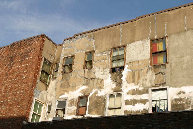 Exterior of a low income rental building. Unpainted exterior of unkept rental housing building stock photos