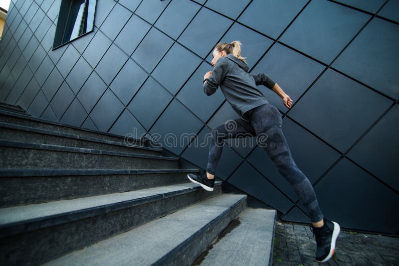 Female athlete running fast up the stairs staircase workout. Female athlete running fast up the stairs - staircase workout stock photo