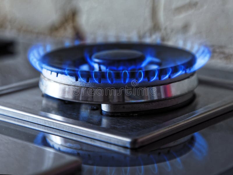 Flames of blue gas. Close up burning fire ring from a kitchen gas stove. Tinted photo.  royalty free stock photos