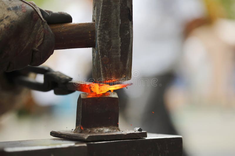 Forging hot iron. Detail shot of hammer forging hot iron at anvil royalty free stock image