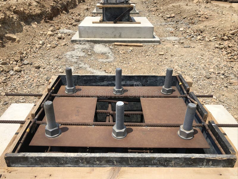 Formwork and reinforcement of concrete foundation with metal anchor bolts designed for the installation of metal columns. Formwork and reinforcement of concrete royalty free stock images