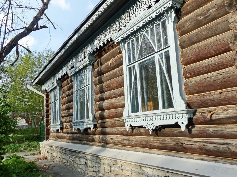 A fragment of the wooden facade hut. The window architraves. Folk art. Russian village. Old wooden houses. Monument of ancient Russian architecture. Golden stock photography