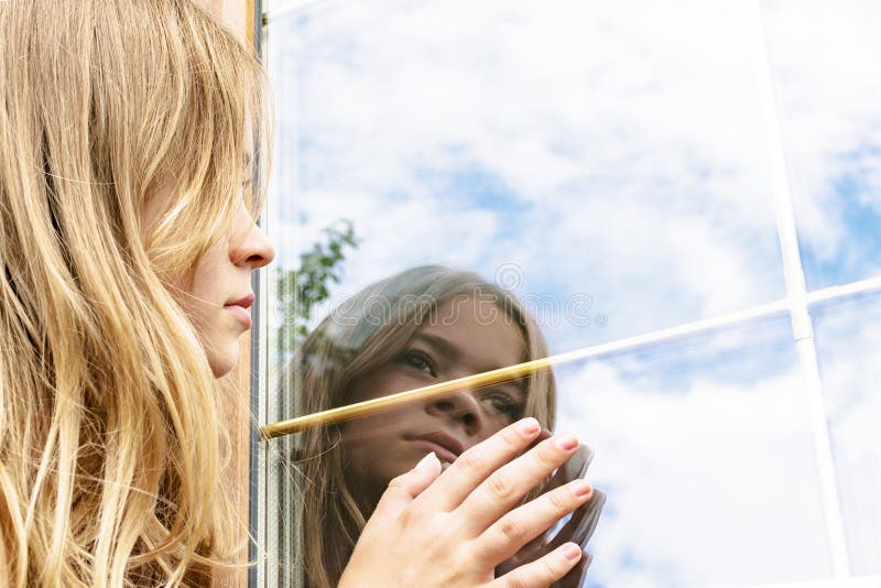 The girl looks at the reflection of the window. The girl looks at her reflection in the window royalty free stock photography