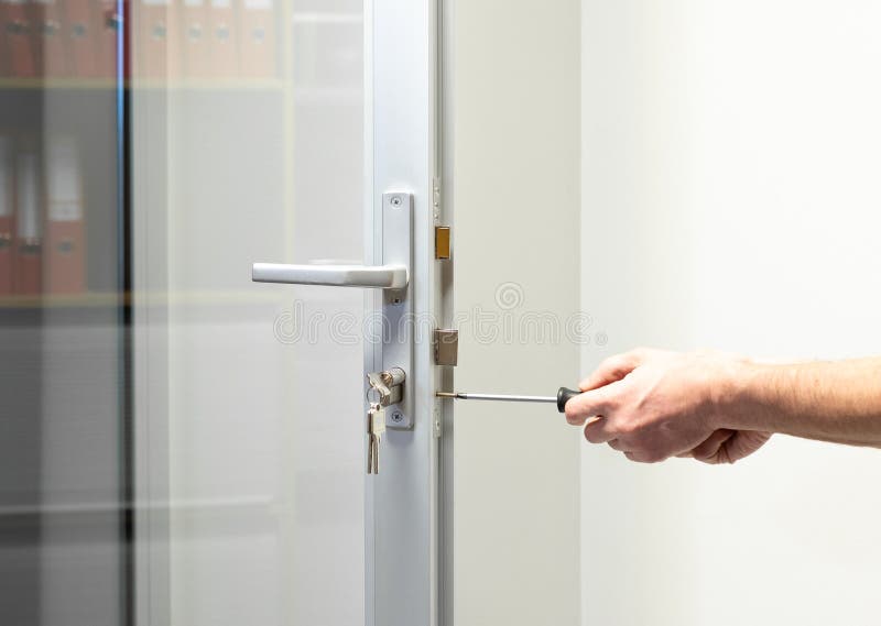 Glass Door knob repairing , worker Installs door knob, woodworker hands close-up royalty free stock images