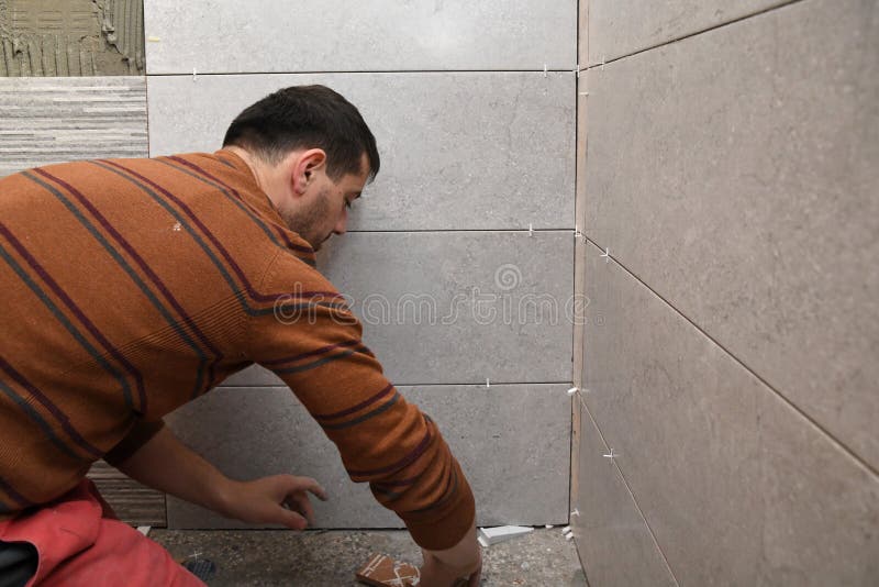 Gluing tiles on the wall. Laying tiles on the wall stock image