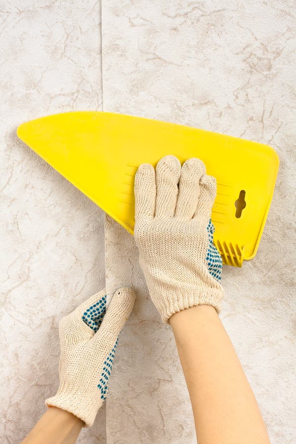 Gluing wallpaper on the wall royalty free stock image