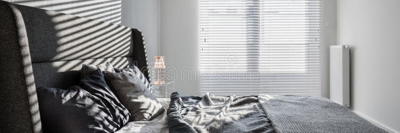 Gray bedroom with window blinds. Panorama of gray bedroom with double bed and window blinds stock photography