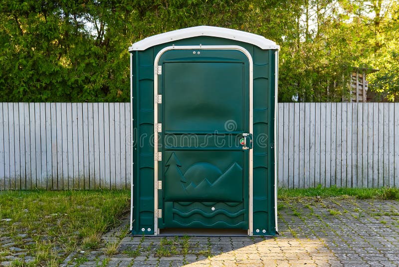 A Green Portable Plastic Toilet in a Park for events. A Green Portable Plastic Toilet in a Park for events stock image