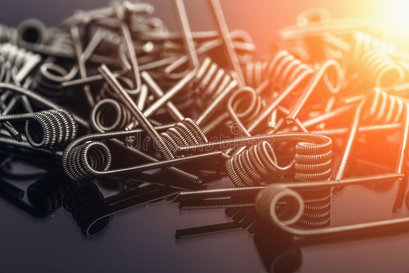 Group of Fussed Clapton Coils for vape or e-cig dripping atomizers or RDA, accessories for vaping, light effect toned. Macro photo stock image