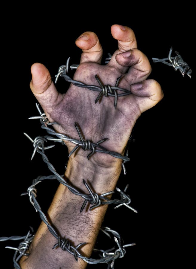 Hand grabbing a barbed wire. Dirty hand grabbing a barbed wire on black background stock photo