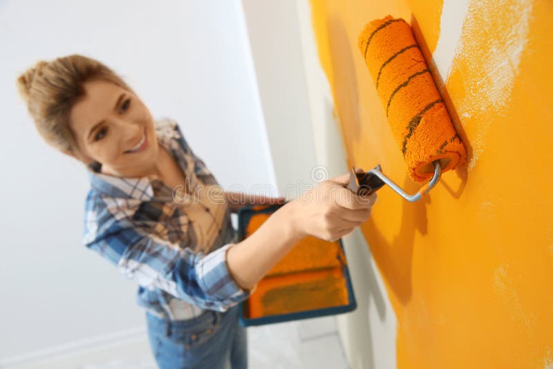 Happy woman painting wall indoors. Home repair royalty free stock photo