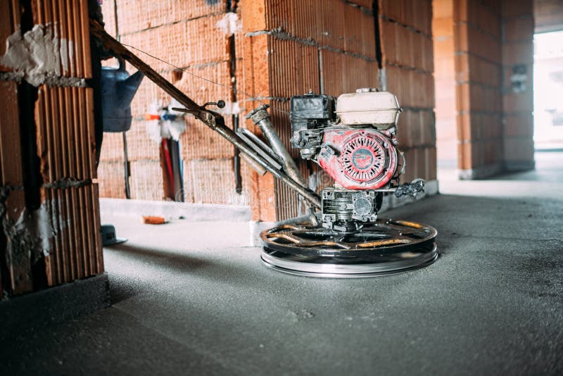 Helicopter concrete floor finishing on construction site. Construction worker finishing concrete screed with power trowel machine. Helicopter concrete floor royalty free stock images