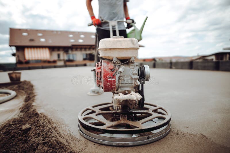 Helicopter concrete floor finishing on construction site. Construction worker finishing concrete screed with power trowel machine. Helicopter concrete floor stock images