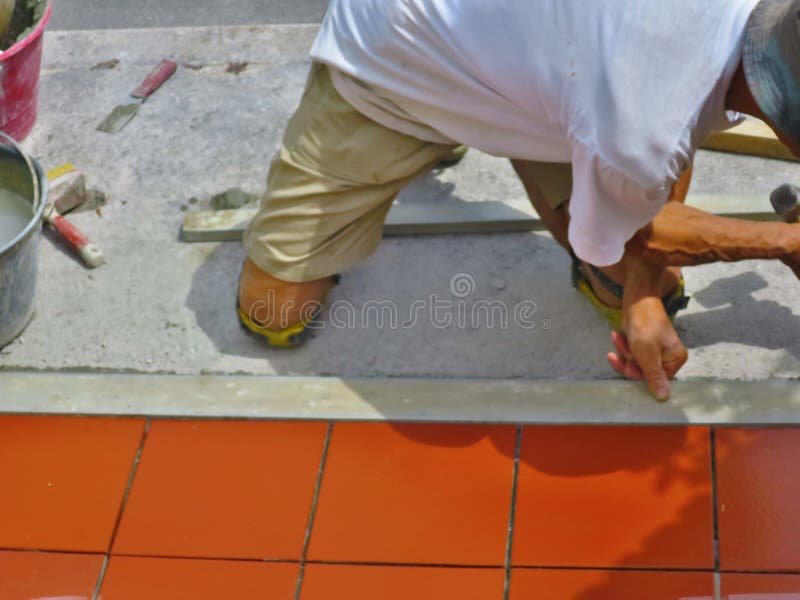 Home improvement, renovation - construction worker tiler is tiling, ceramic tile floor adhesive.  stock photos