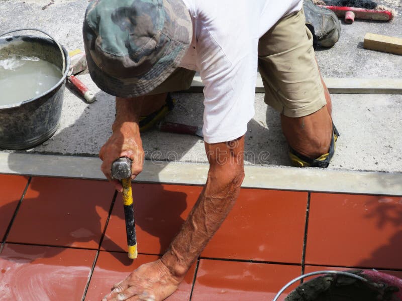 Home improvement, renovation - construction worker tiler is tiling, ceramic tile floor adhesive.  royalty free stock image