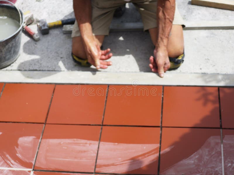 Home improvement, renovation - construction worker tiler is tiling, ceramic tile floor adhesive.  stock image