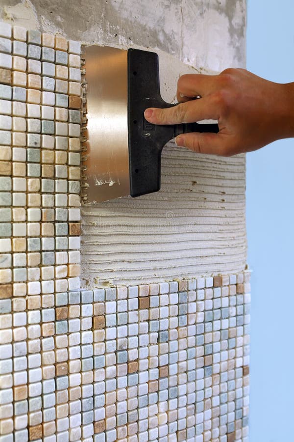 Home repair: installing the mosaic tile on the wall stock photography