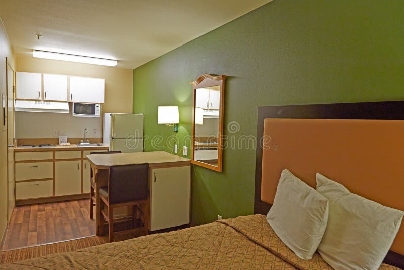 Hotel room with kitchen. Family style hotel room with bed, table and kitchen stock photos