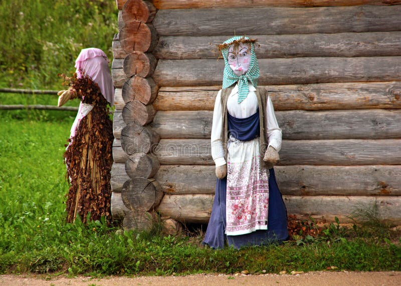 The hut in the Russian village. Scarecrow next to the hut. The hut in the Russian village/ Mikhailovskoe, Pskov royalty free stock photos