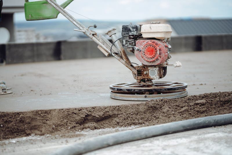 Industrial tools - helicopter concrete screed  finishing. Construction worker finishing concrete screed with power trowel machine. Helicopter concrete screed royalty free stock image