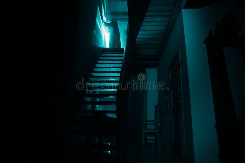 Inside of old creepy abandoned mansion. Silhouette of horror ghost standing on castle stairs to the basement. Spooky dungeon stone. Stairs in old castle with stock photos