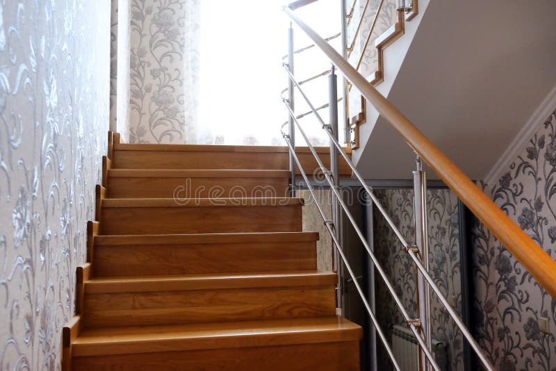 Interfloor stairs from the valuable breeds of wood for the cottage. Wooden staircase to the second floor. Modern wooden staircase. With brown wooden railing royalty free stock photo