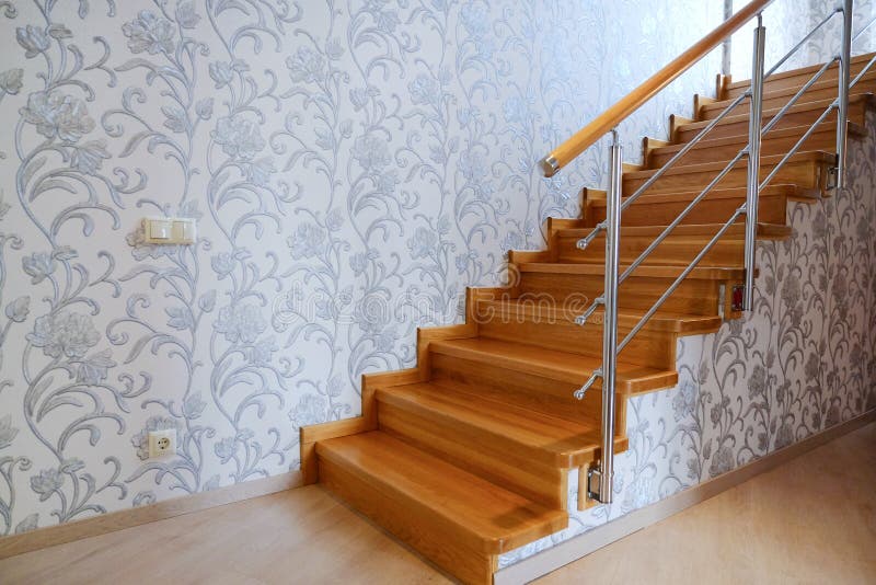 Interfloor stairs from the valuable breeds of wood for the cottage. Wooden staircase to the second floor. Modern wooden staircase. With brown wooden railing stock photos