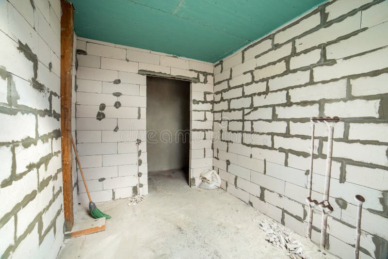 Interior of an apartment room with bare walls and ceiling under construction.  royalty free stock image