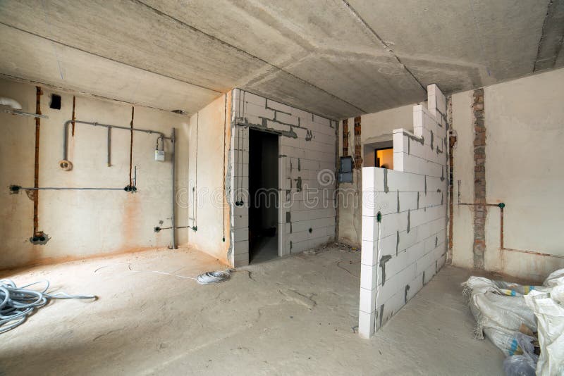 Interior of an apartment room with bare walls and ceiling under construction.  royalty free stock image