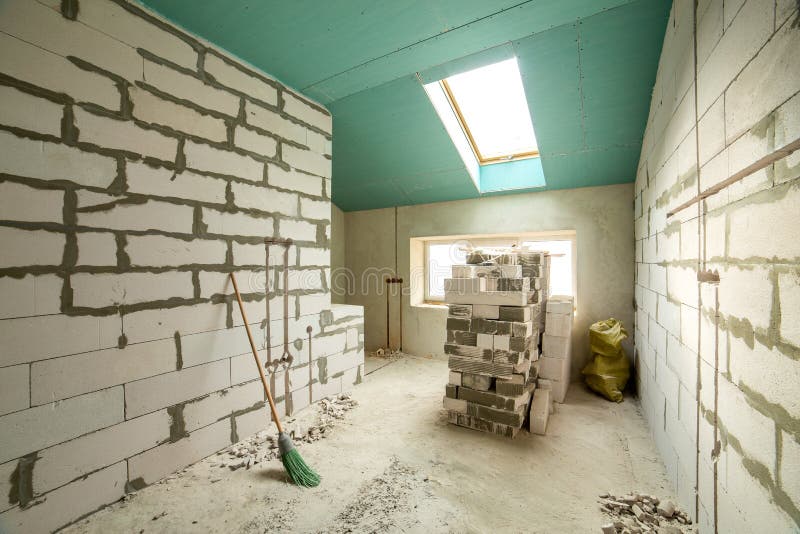 Interior of an apartment room with bare walls and ceiling under construction.  stock photo