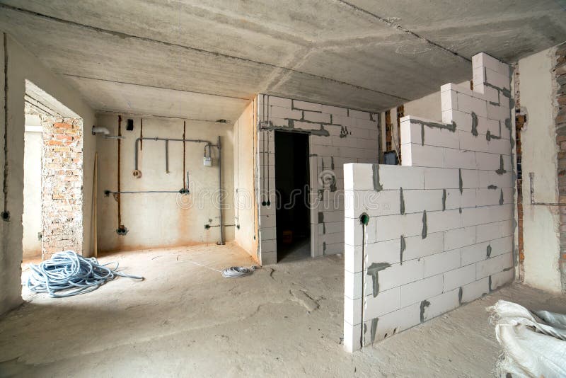 Interior of an apartment room with bare walls and ceiling under construction.  stock photo