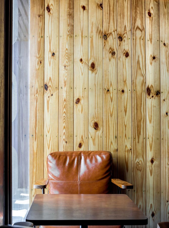 Interior cafe with light brown vintage leather sofa. And wooden coffee table on blank wooden wall background near window glass vertical style stock photos