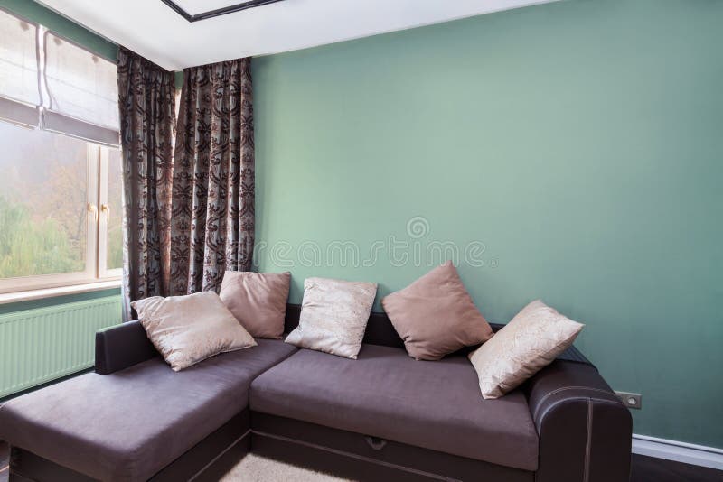 Interior design with dark relax sofa and colorful cushions window curtains and olive color wall stock photo