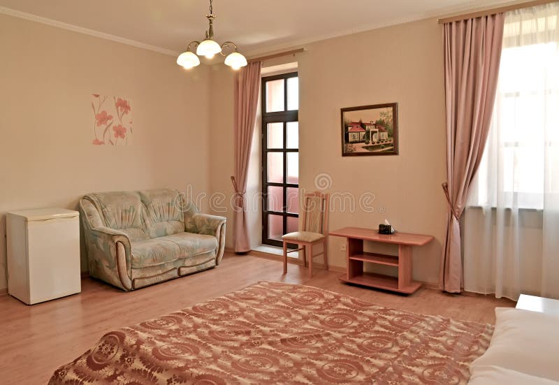 An interior of the hotel rr of the hotel room in pink tones with an exit to a balcony. Modern classics. An interior of the hotel room in pink tones with an exit royalty free stock image