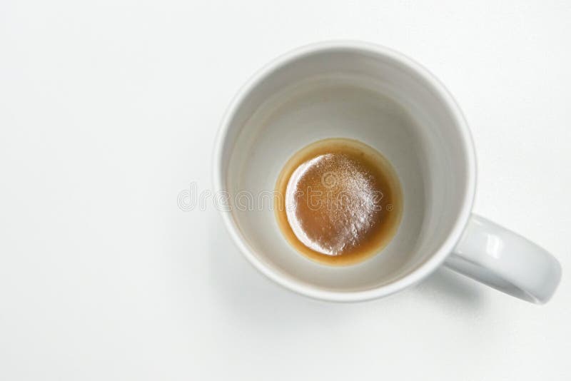 Isolated white mug with coffee residue at bottom. Of the glass royalty free stock image