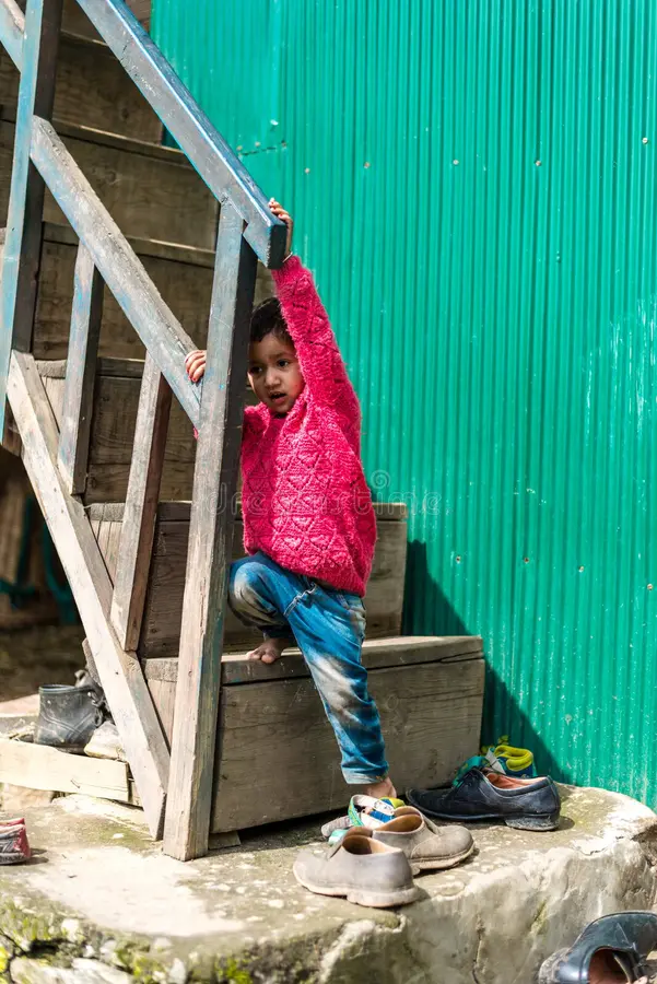 Kullu, Himachal Pradesh, India - September 01, 2018 : Himalayan kid at Stairs of traditional wooden house in mountain stock photos