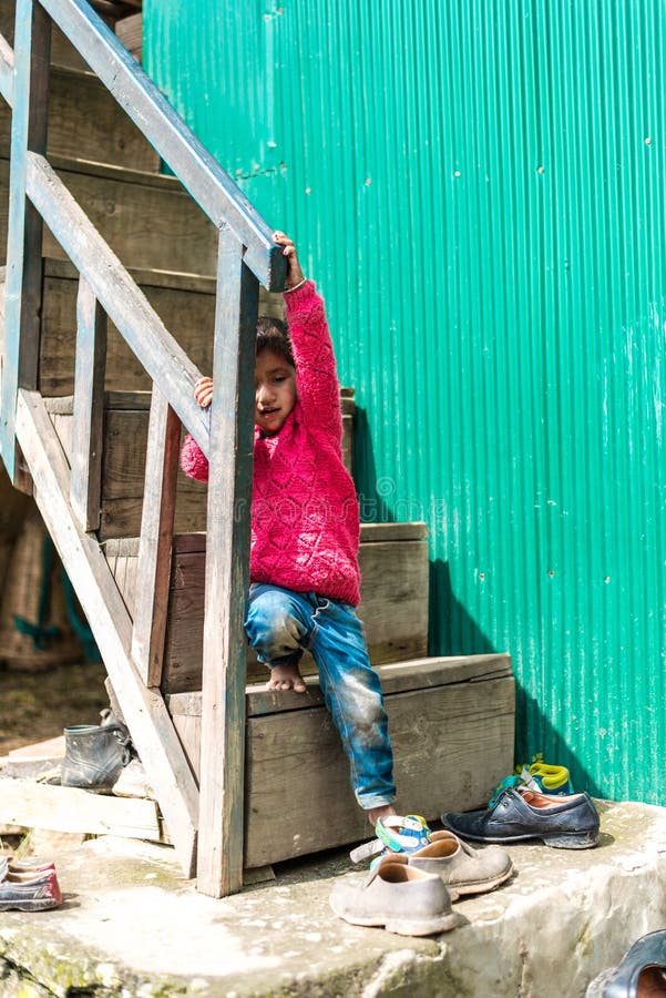 Kullu, Himachal Pradesh, India - September 01, 2018 : Himalayan kid at Stairs of traditional wooden house in mountain stock images