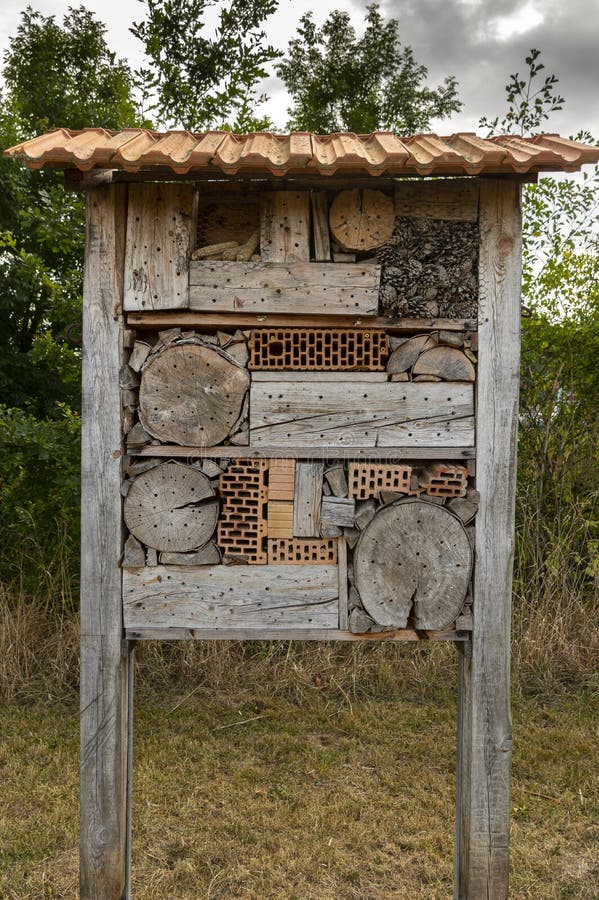 Large and beautiful insect hotel in the corridor near a creek with a tiled roof as protection against rain. In germany royalty free stock images