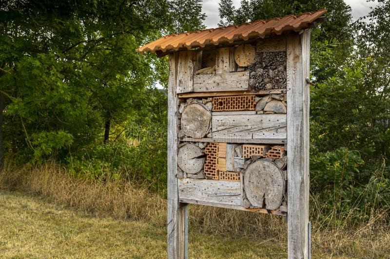 Large and beautiful insect hotel in the corridor near a creek with a tiled roof as protection against rain. In germany royalty free stock images