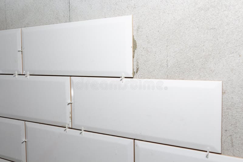 Laying tiles on the wall with gaskets, repair work royalty free stock photo