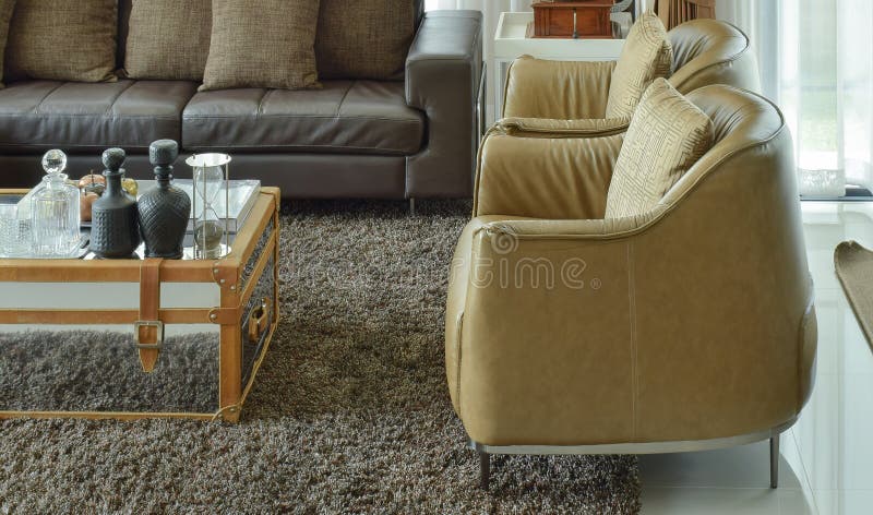 Light brown leather armchairs and dark brown leather sofa in the living room royalty free stock images